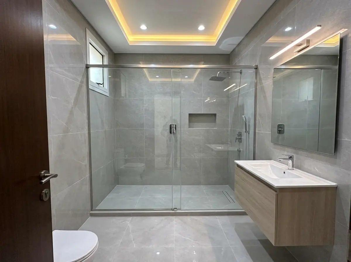 Remodelled bathroom with glass walk-in shower and floating vanity in JVT Dubai