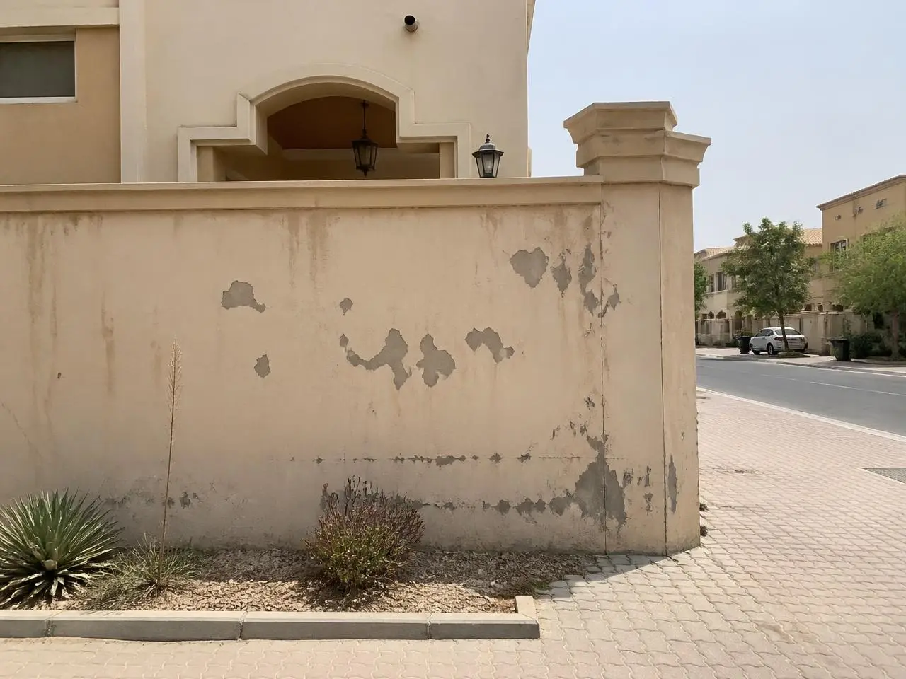 Villa boundary wall with peeling faded paint before exterior painting in Mudon Dubai