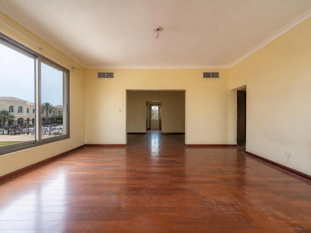 Villa living room with scratched red wood floors before renovation in Arabian Ranches