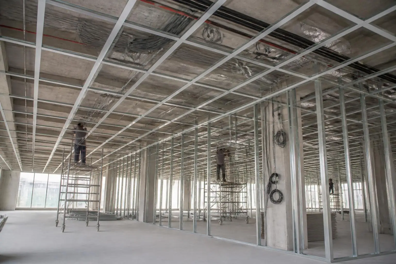 Gypsum ceiling grid and partition framing being installed in a shell-and-core space
